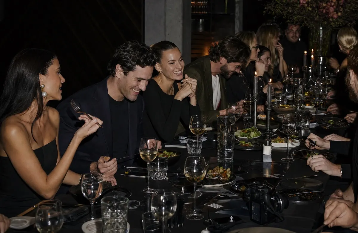 Munichtrend guests laughing at a long candlelit dinner table